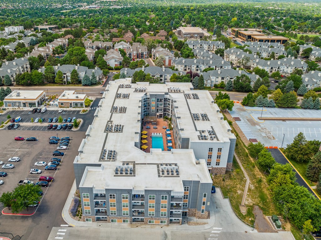 an aerial view of a large apartment complex with trees in the background