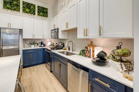 a kitchen with blue and white cabinets and a sink