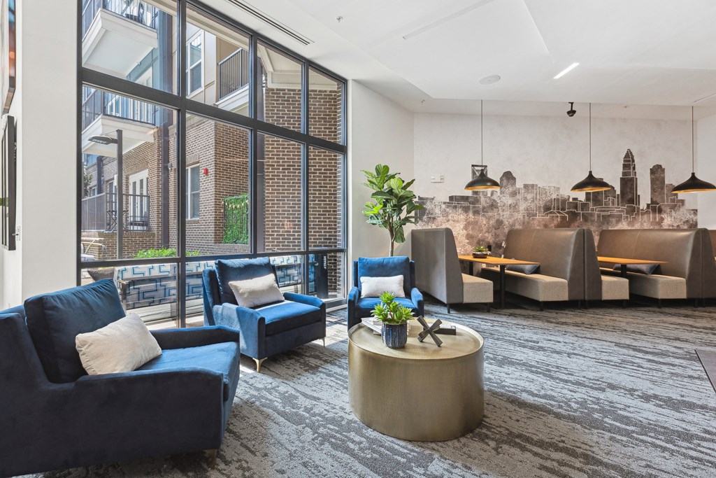 a large living room with blue couches and chairs and a large window