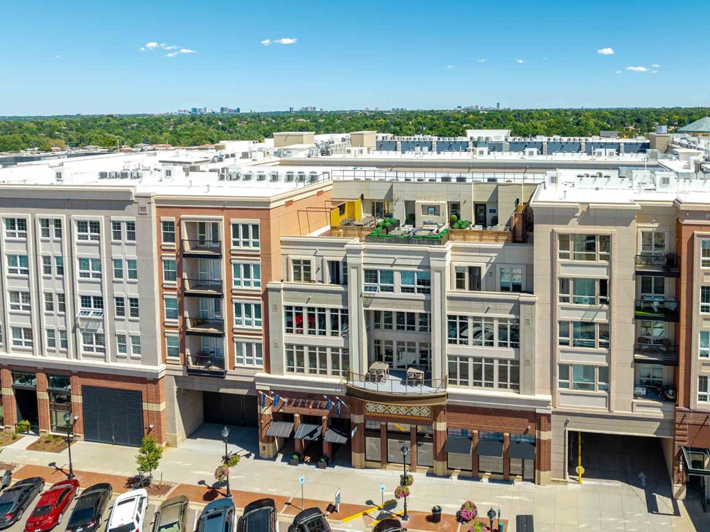 an aerial view of a large building with a parking lot in the foreground