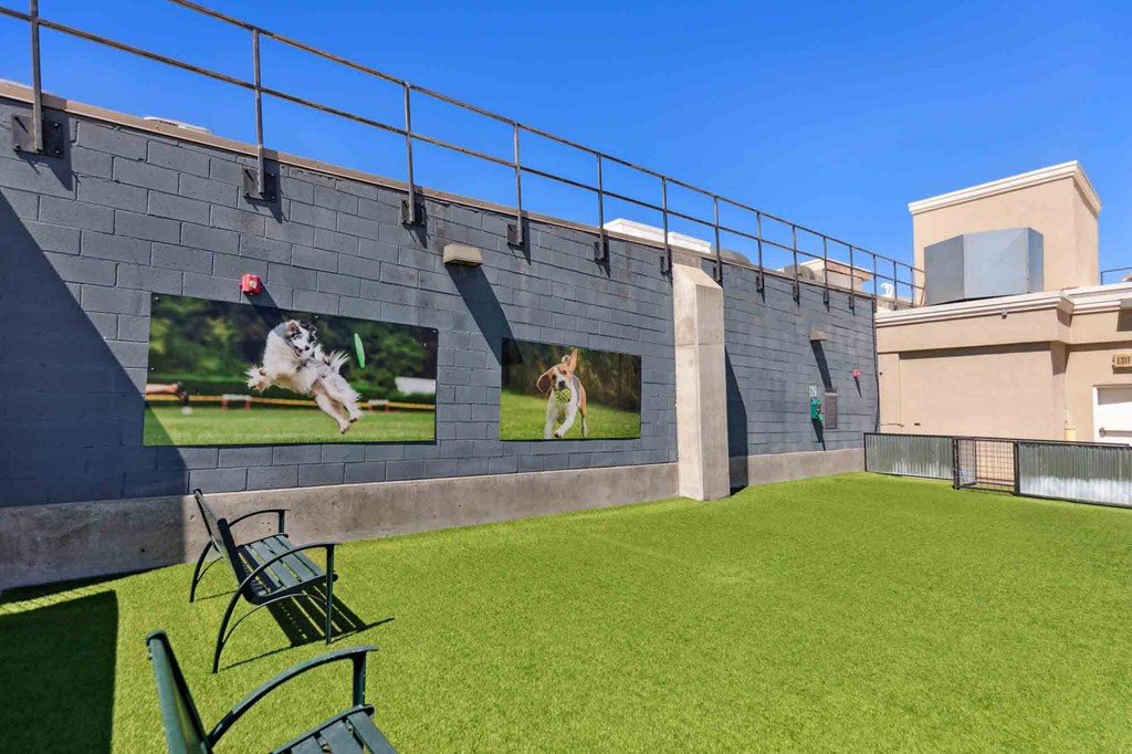 a courtyard with a bench and chairs and two large screens on the wall with pictures of a