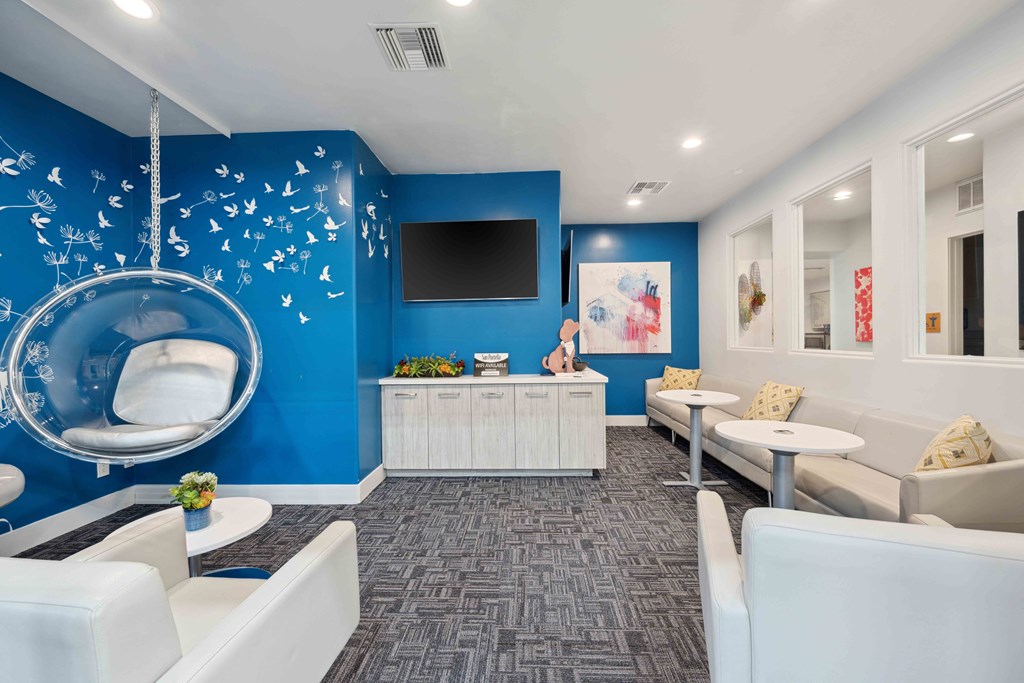 business center with couches and a tv in front of a blue wall