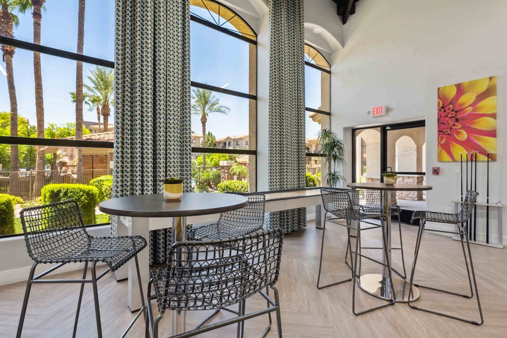 tables and chairs in the lobby of a building with large windows