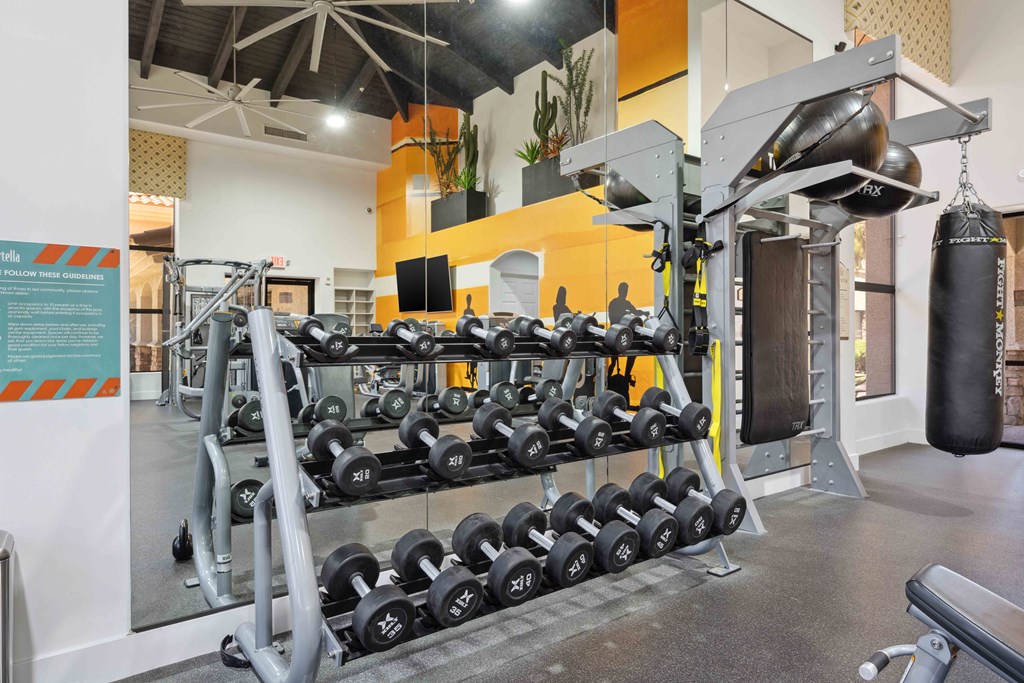 a view of the fitness center with weights on the rack and a punching bag at apartments