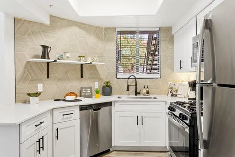 San Portella Apartments with white cabinets and stainless steel appliances