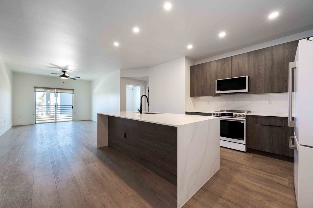 a kitchen with brown cabinets and stainless steel appliances at Slate Scottsdale, lofts for rent Phoenix.