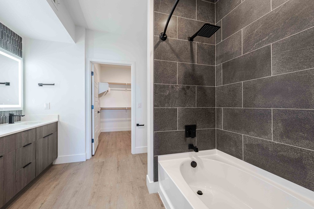 a bathroom with a tub and a shower and a sink