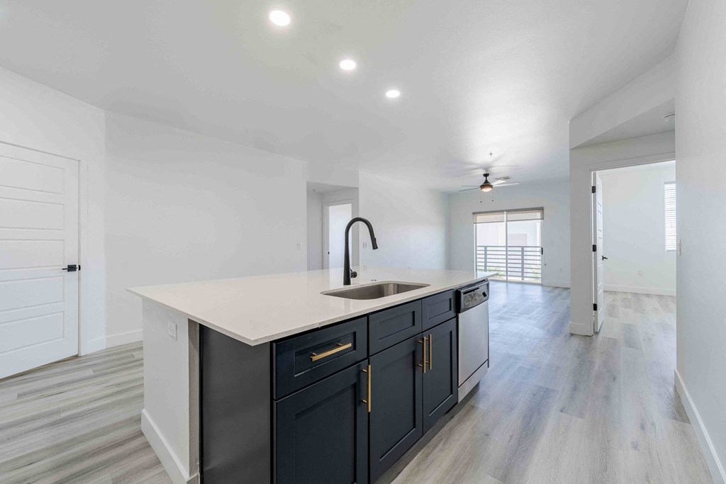 a white and black kitchen with a large counter top and a sink