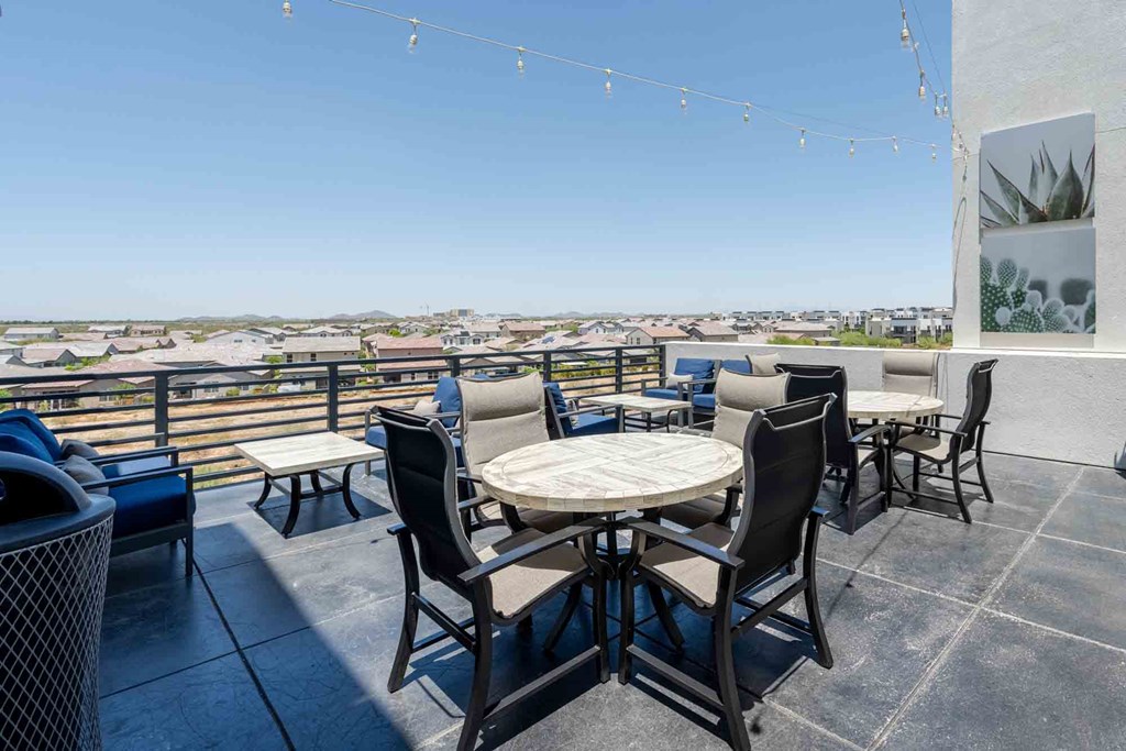 tables and chairs on a rooftop patio with a view of scottsdale arizona
