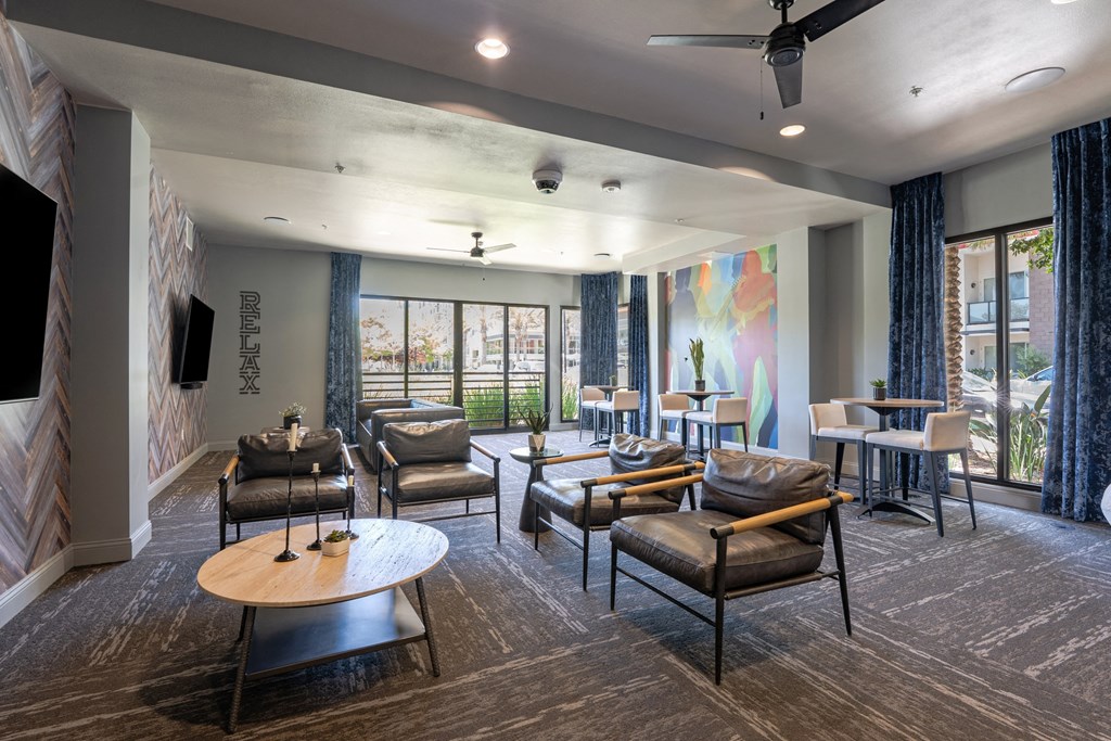 a living room with couches chairs and tables and a tv