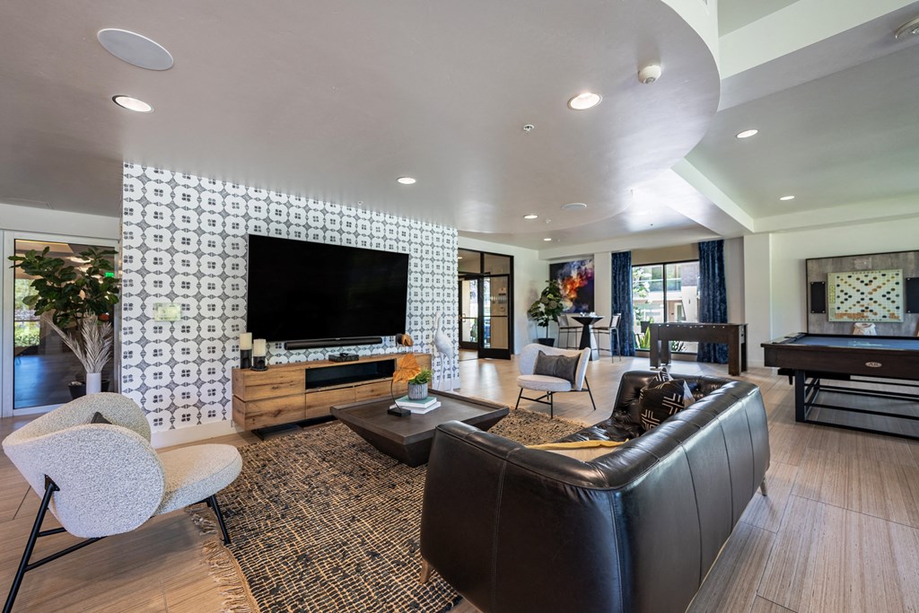 a living room with a leather couch and a television