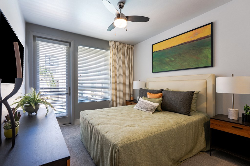 a bedroom with a large bed and a ceiling fan