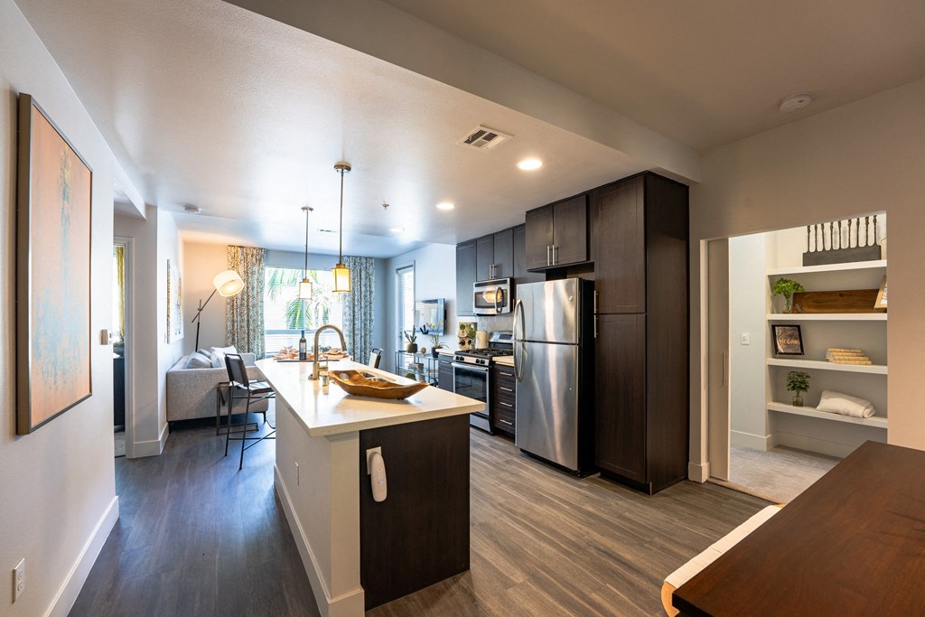 a kitchen and living room with stainless steel appliances and wood floors