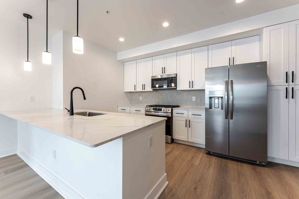 kitchen at The Vive Collection, featuring white cabinets and a kitchen island.