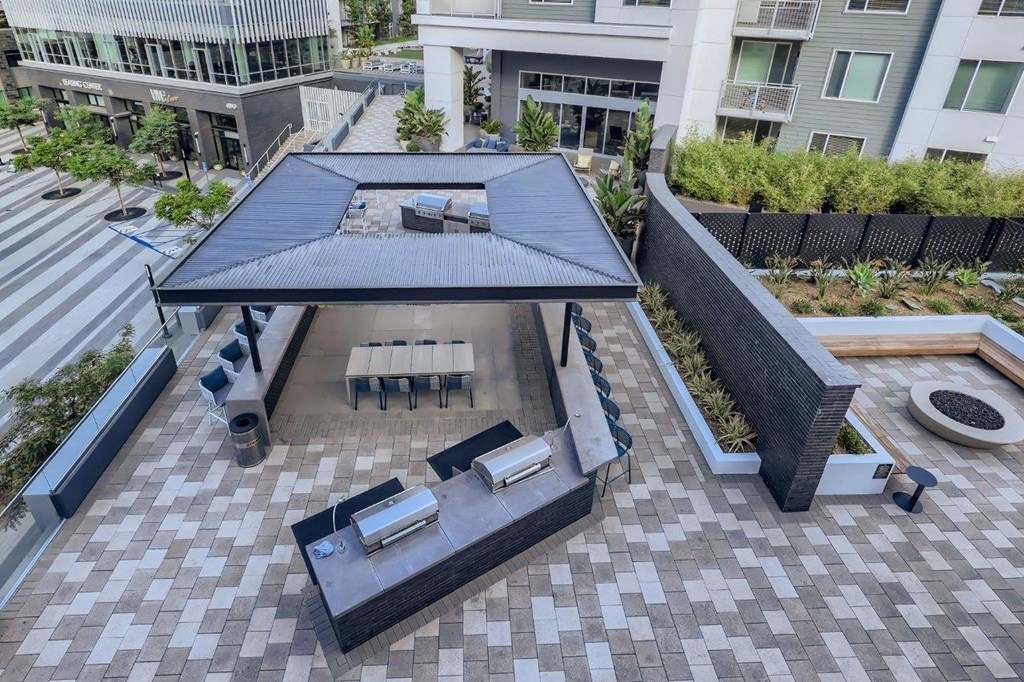 a rooftop view of a patio with a table and chairs