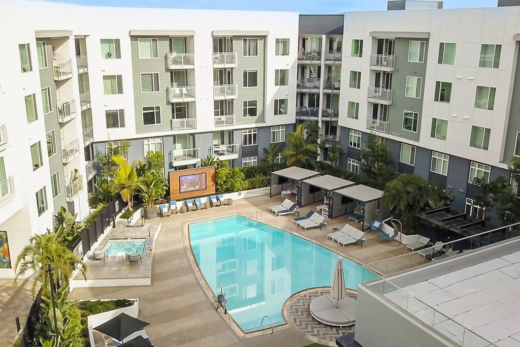 an overhead view of an apartment building with a swimming pool