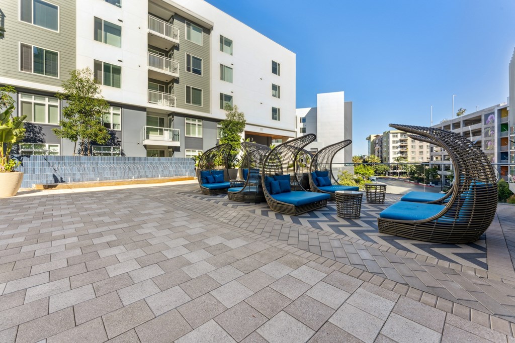 a group of blue chairs on a patio in front of an apartment building