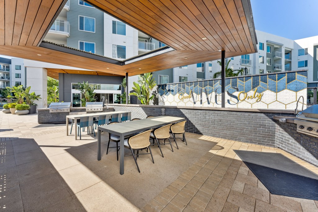 a patio with tables and chairs and a building in the background