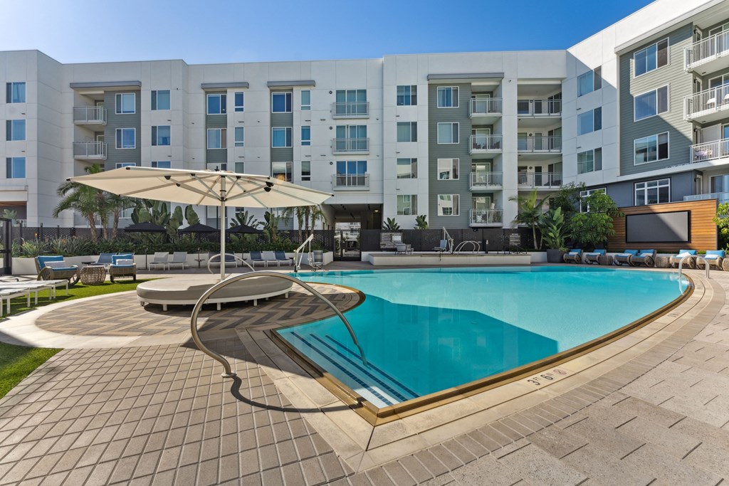 a swimming pool with an apartment building in the background