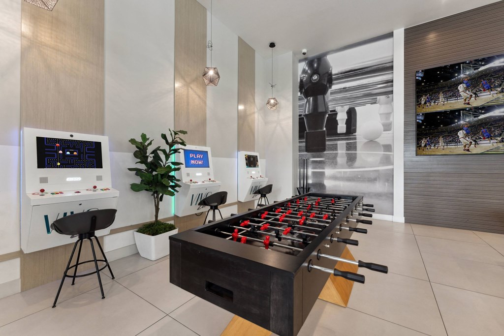 a game room with a foosball table and chairs