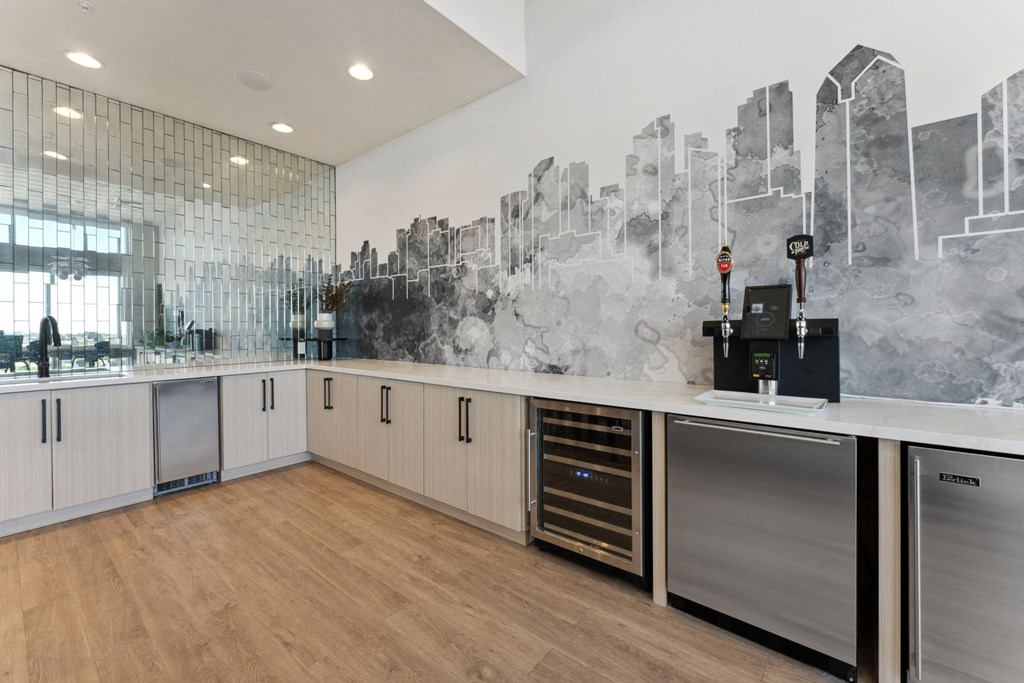 a kitchen with white cabinets and a city mural on the wall