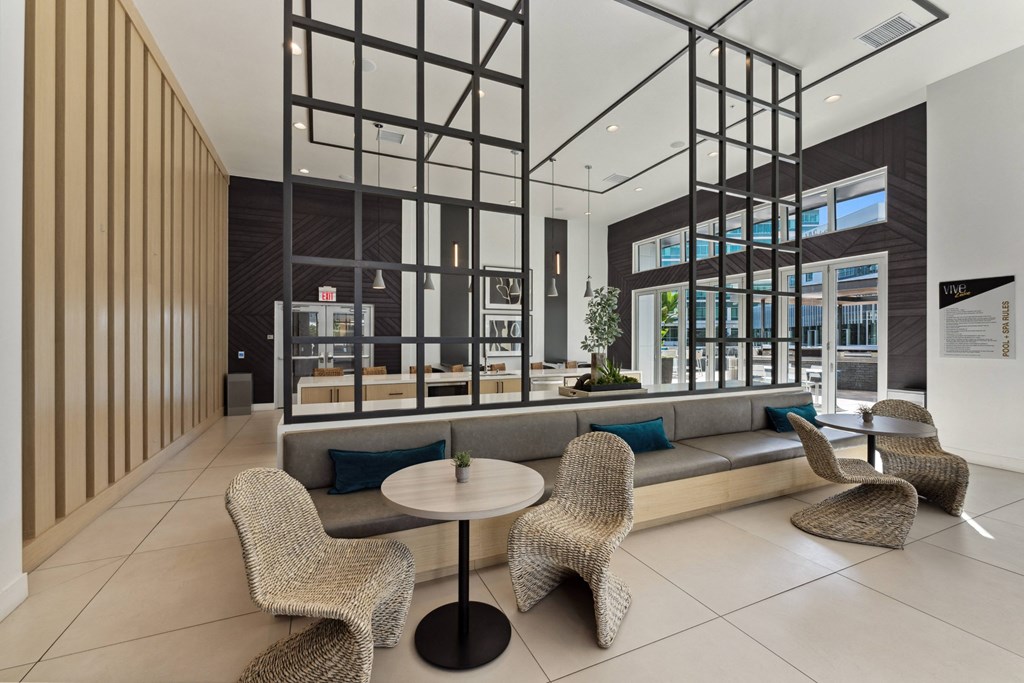 a lounge area with rattan chairs and a table in a lobby