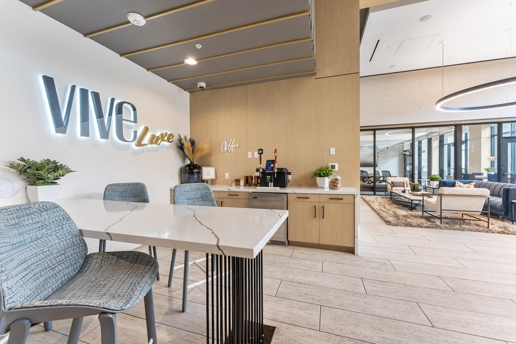 a communal area with a white table and chairs and a vue lounge sign on