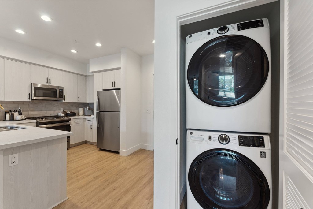 a washer and dryer in a living room next to a kitchen