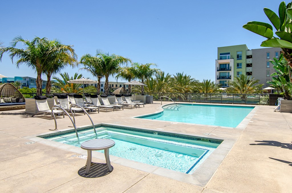 a swimming pool with chaise lounge chairs and palm trees
