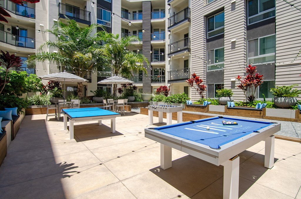two ping pong tables in an outdoor area of an apartment building
