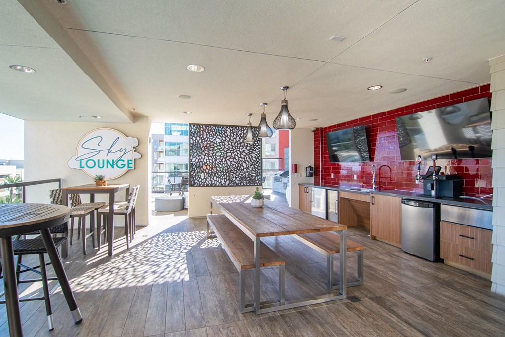 a dining area with a wooden table and chairs and a kitchen
