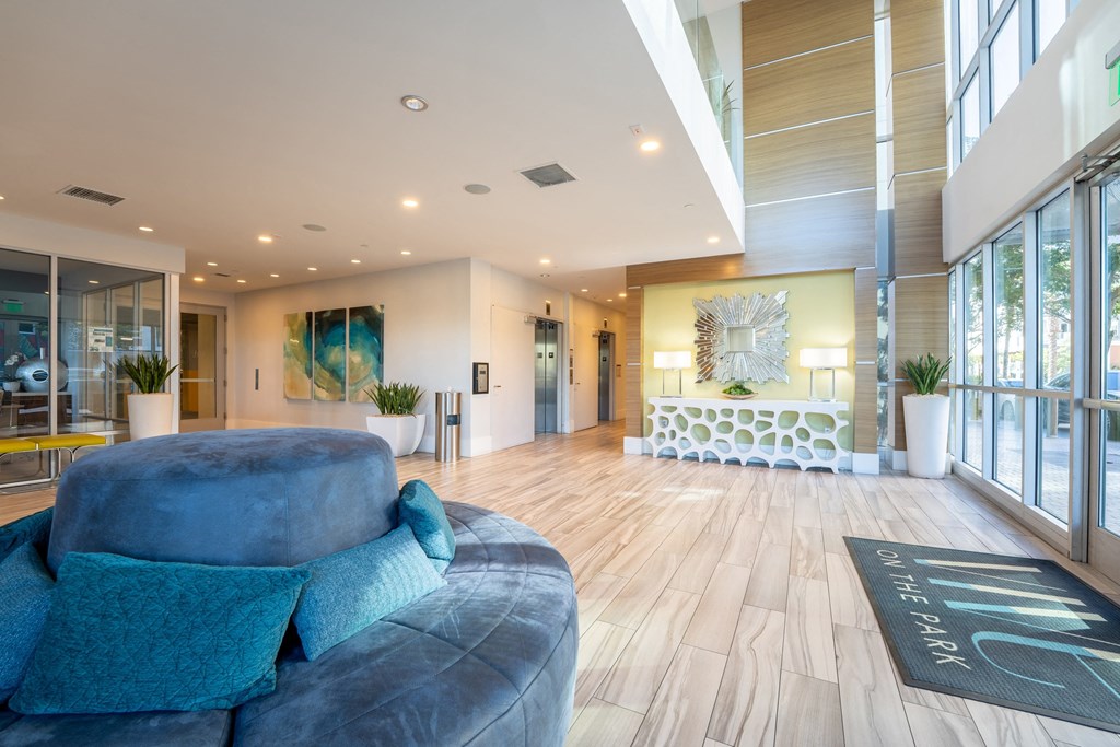 a living room with a blue couch and large windows