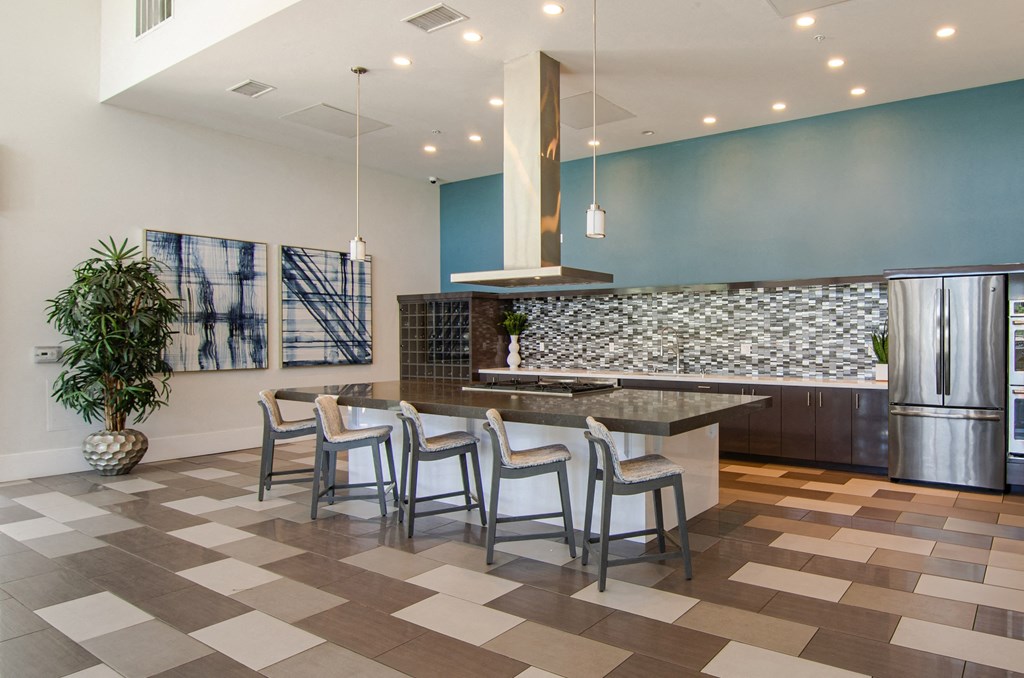 a kitchen with a large island and a stainless steel refrigerator