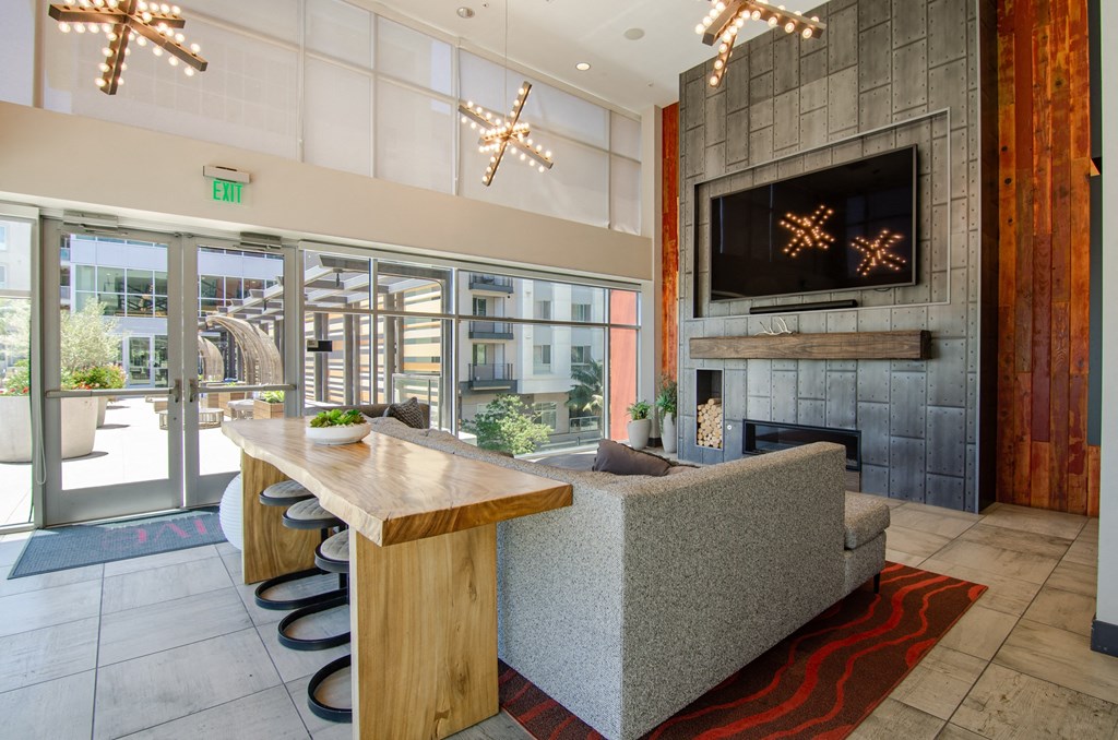 the lobby of a condo with a living room with a fireplace and a dining room