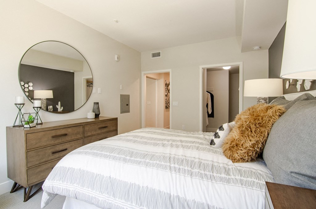 a bedroom with a large bed and a mirror