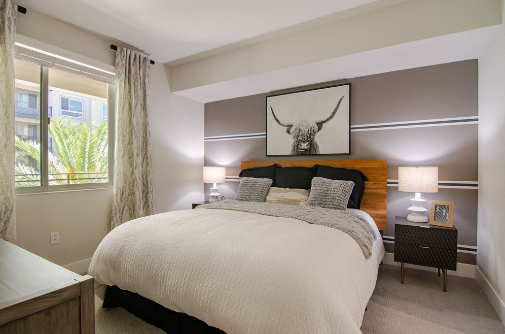 a bedroom with a bed and a picture of a bull on the wall