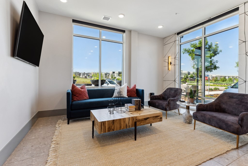 a living room with a large window and a tv on the wall