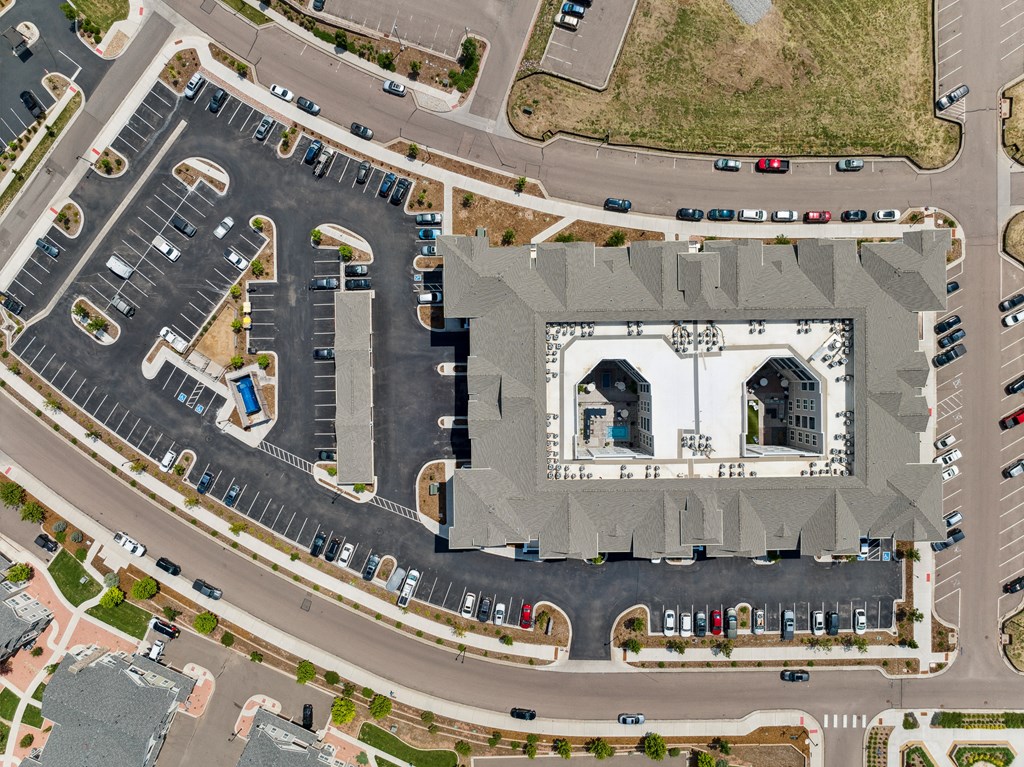 an aerial view of a parking lot with cars parked around it