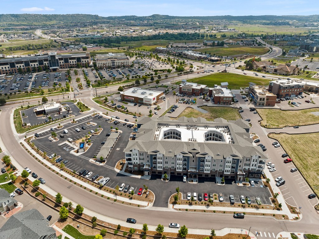 an aerial view of a large building with a large parking lot in front of it