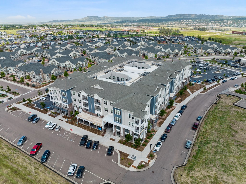 an aerial view of a large apartment complex with cars parked in the parking lot