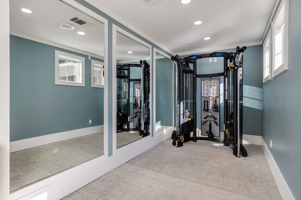 a home gym with mirrors and equipment in a room with blue walls