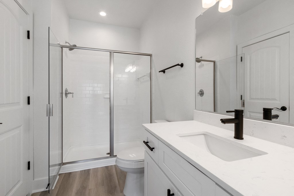 a white bathroom with a shower and a sink and a toilet