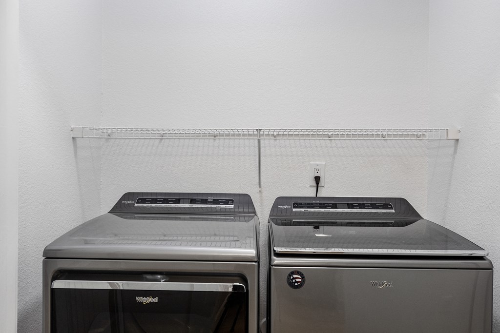 a kitchen with two stainless steel washers and dryers