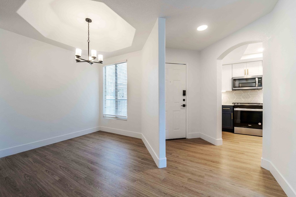 an empty living room with white walls and wood floors