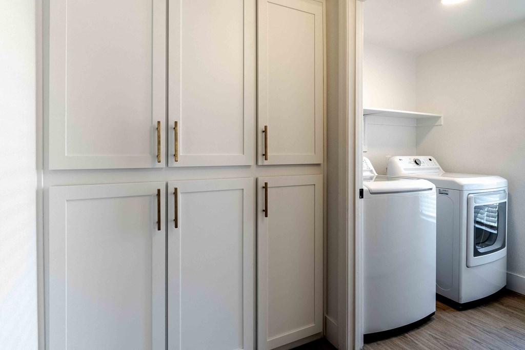 a laundry room with white cabinets and washer and dryer