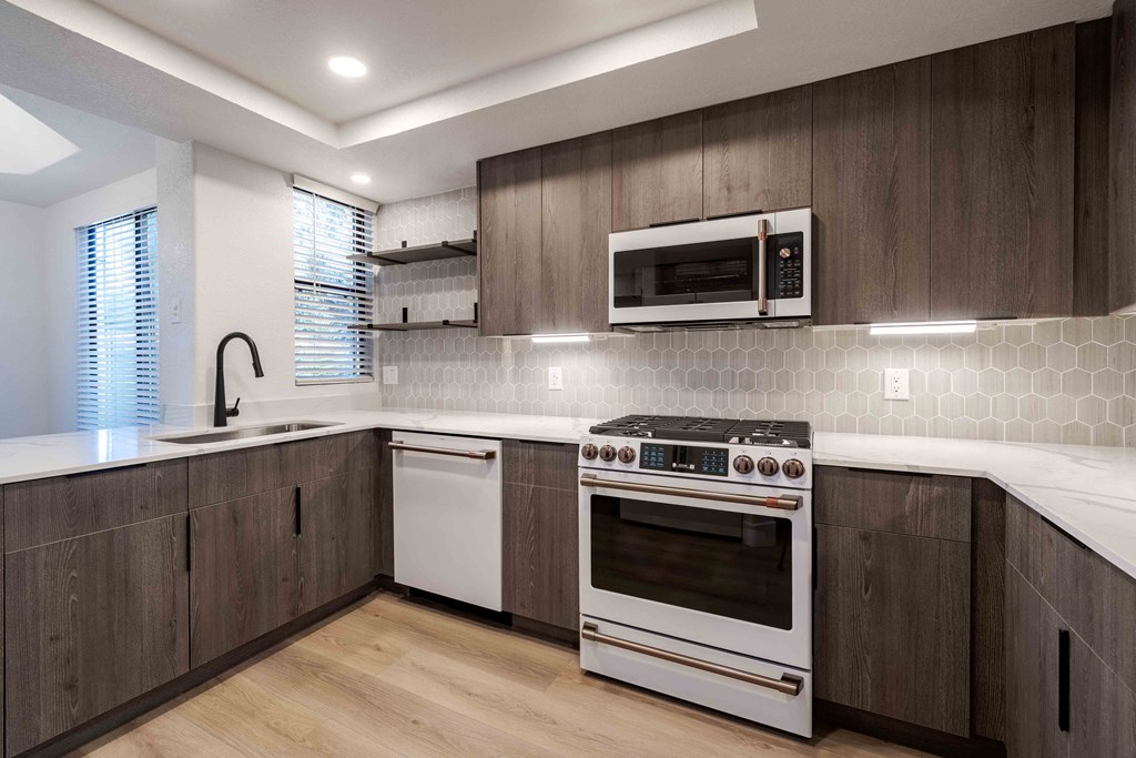 a kitchen with a stove and a sink and a microwave