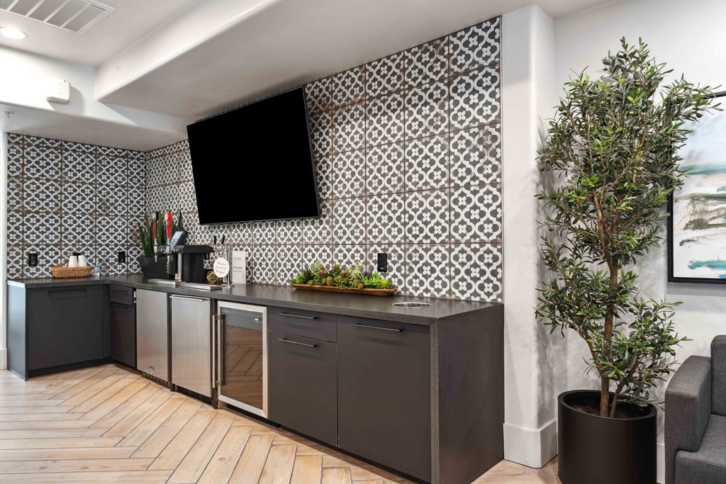a kitchen with grey cabinets and a large plant in a pot