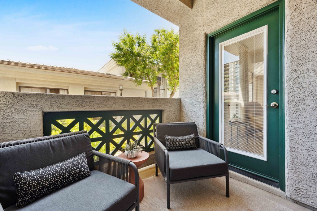 a balcony with two chairs and a table