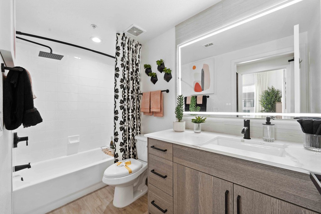 a bathroom with a white toilet next to a bathtub with a shower curtain