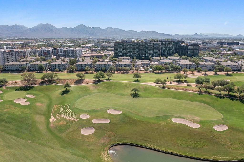 an aerial view of a golf course with a city in the background